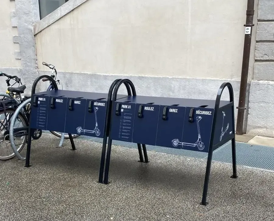 Deux stations Park'Easy bleu marine installées devant un bâtiment en pierre